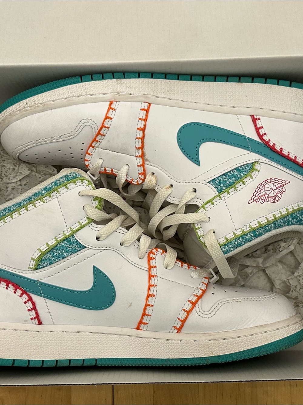 Nike Jordan 1s White Low-Top Sneakers with Teal Swoosh and Multicolor Stitching